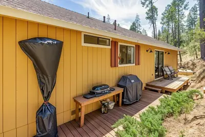 a yellow house with a deck with a grill at The Happy Place Mountain View Home in Groveland