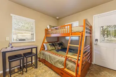 a bedroom with a bunk bed with a desk and a bed at Acorn Cottage - Hidden gem in green heaven, getaway to Bass Lake & Yosemite in Oakhurst