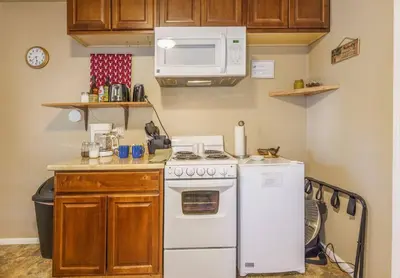 a kitchen with a white stove and a microwave at Acorn Cottage - Hidden gem in green heaven, getaway to Bass Lake & Yosemite in Oakhurst