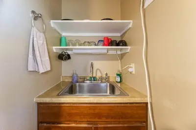 a kitchen with a sink and a shelf above it at Acorn Cottage - Hidden gem in green heaven, getaway to Bass Lake & Yosemite in Oakhurst