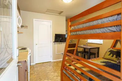 a bedroom with a bunk bed and a kitchen with a desk at Acorn Cottage - Hidden gem in green heaven, getaway to Bass Lake & Yosemite in Oakhurst