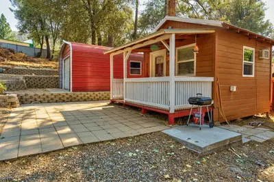 a small house with a grill in front of it at Acorn Cottage - Hidden gem in green heaven, getaway to Bass Lake & Yosemite in Oakhurst