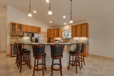 a kitchen with wooden cabinets and bar stools at Lukins Lodge By The Lake Hot Tub in South Lake Tahoe