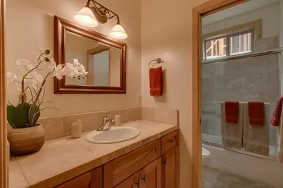 a bathroom with a sink and a toilet and a mirror at Lukins Lodge By The Lake Hot Tub in South Lake Tahoe