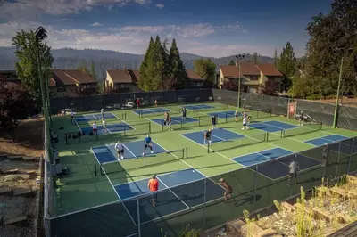 a group of people playing tennis on a tennis court at Pet Friendly The Hideout Yosemite Home in Groveland