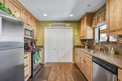 a kitchen with wooden cabinets and a white door at Bigfoot Retreat Home Close to Beach in Groveland