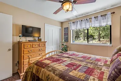 a bedroom with a bed and a flat screen tv at Bigfoot Retreat Home Close to Beach in Groveland