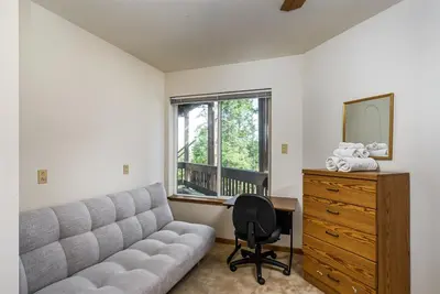 a living room with a couch and a desk and a mirror at Miner's Claim - Home with 2 Decks & Pool in Groveland