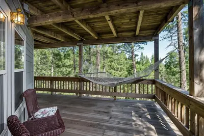 a hammock on the porch of a cabin at Miner's Claim - Home with 2 Decks & Pool in Groveland