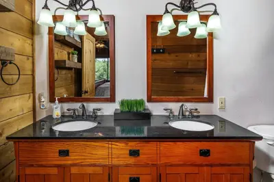 a bathroom with two sinks and two mirrors at Rustic Modern Cabina De Alba in Groveland