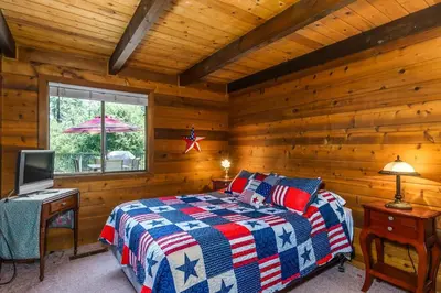 a bedroom with a bed and a television in a cabin at Rustic Modern Cabina De Alba in Groveland