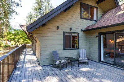 a house with two chairs and a table on a deck at Rustic Modern Cabina De Alba in Groveland