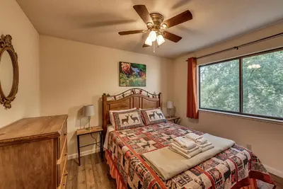 a bedroom with a bed and a ceiling fan at Pet Friendly Grizzly Blair Lodge Cabin in Groveland