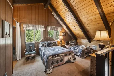 a bedroom with two beds in a log cabin at Lakefront Cozy Cabin on the Cove in Groveland