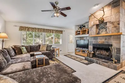 a living room with a couch and a fireplace at Star of the Mountain Yosemite Home in Groveland