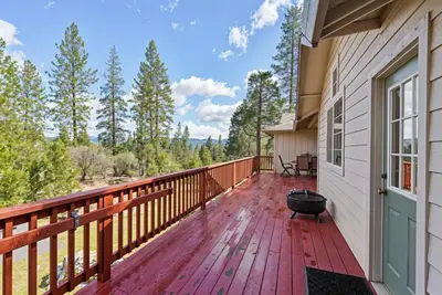 a wooden deck with a grill on the side of a house at Star of the Mountain Yosemite Home in Groveland