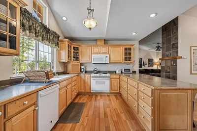 a large kitchen with wooden cabinets and white appliances at Star of the Mountain Yosemite Home in Groveland