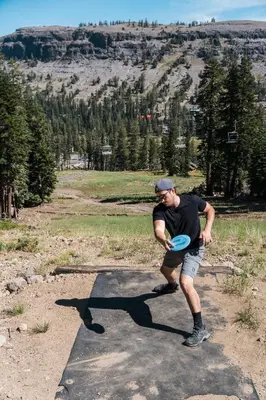 a man is playing with a frisbee in a field at Luxurious 2 Bedroom Base Camp Condo - Steps from Kirkwood Village condo in Kirkwood