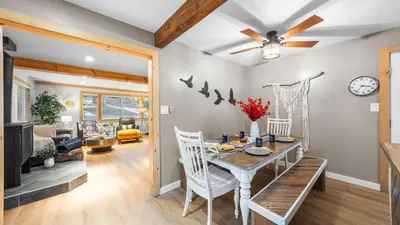 a dining room and living room with a table and chairs at Sweet Pine Deck Hot Tub Cozy Modern Interior Close to Ski Resort in Pomins
