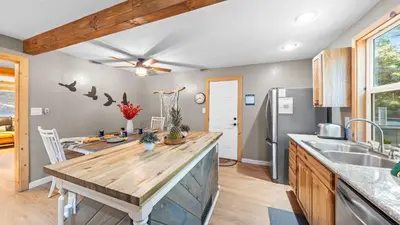 a kitchen with a wooden counter top and a sink at Sweet Pine Deck Hot Tub Cozy Modern Interior Close to Ski Resort in Pomins