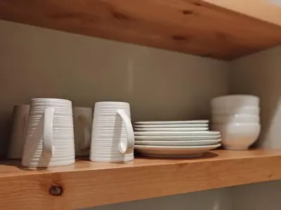 a shelf with white plates and bowls on it at Lakeside hotel room #1 in Kings Beach in Kings Beach