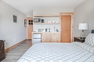 a bedroom with a white bed and a kitchen at Lakeside hotel room #1 in Kings Beach in Kings Beach