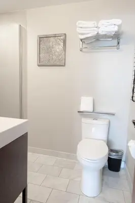 a white bathroom with a toilet and towels at Lakeside Hotel room #6 in Kings Beach in Kings Beach