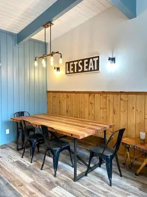a wooden table with chairs and a sign that reads lets eat at Top rated cabin w/spa Walk to the Village & Golf in Mammoth Lakes