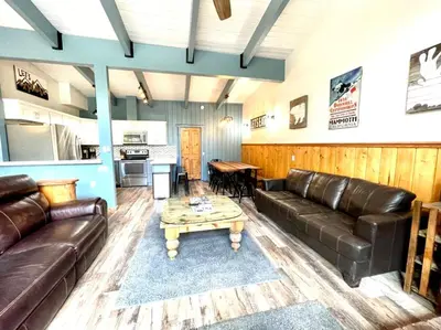 a living room with leather furniture and a table at Top rated cabin w/spa Walk to the Village & Golf in Mammoth Lakes