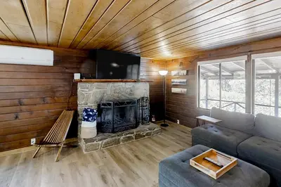 a living room with a couch and a fireplace at Sugar Pine Log Cabin in Oakhurst