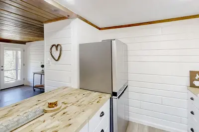 a kitchen with white walls and a wooden counter top at Sugar Pine Log Cabin in Oakhurst