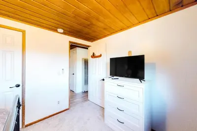 a living room with a flat screen tv on a wall at Sugar Pine Log Cabin in Oakhurst