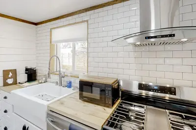 a kitchen with a stove top oven and a sink at Sugar Pine Log Cabin in Oakhurst