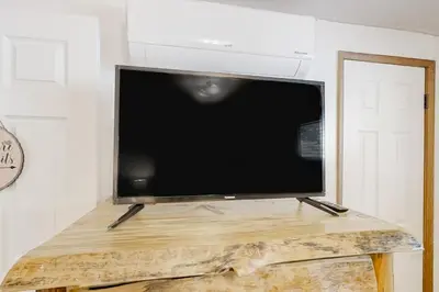 a flat screen tv sitting on top of a wooden table at Sugar Pine Log Cabin in Oakhurst