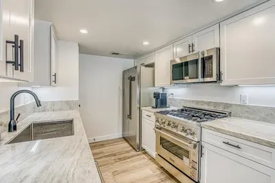 a kitchen with white cabinets and a stove top oven at Slide Creek Retreat in Bass Lake