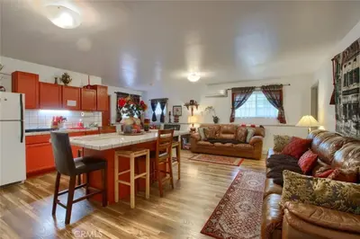 a kitchen and living room with red cabinets and a table at Beautiful Pet-Friendly Spacious Lodge near Yosemite & Lakes 12 Beds 6 BR up to 16 people in Oakhurst