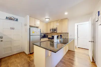 a kitchen with a counter top and a refrigerator at Chamonix 20 in Mammoth Lakes
