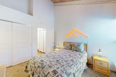 a bedroom with a bed and a white wall at Chamonix 20 in Mammoth Lakes