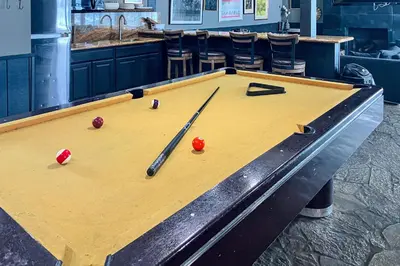 a pool table with balls and bats on it at Chamonix 20 in Mammoth Lakes