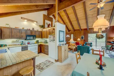 a kitchen and living room with wooden walls and ceilings at Grizzly Cabin in Truckee