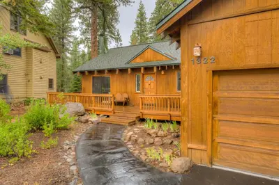 a wooden house with a porch and a garage at Grizzly Cabin in Truckee