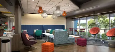a restaurant with colorful chairs and tables and windows at Tru By Hilton Manteca in Manteca