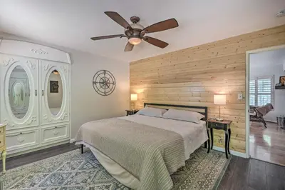 a bedroom with a bed and a ceiling fan at 1 Mi to Jenkinson Lake Apples Chalet with Deck in Pollock Pines