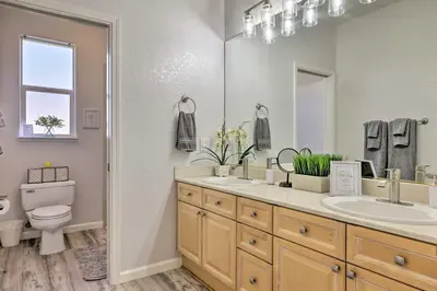 a bathroom with two sinks and a toilet and a mirror at Family-Friendly Modesto Home with Grill and Yard in Modesto