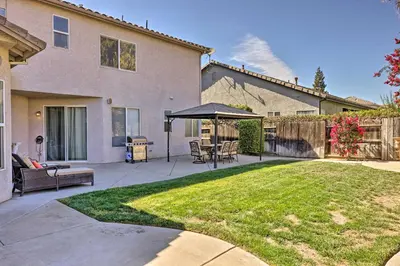 a patio with a table and an umbrella in a yard at Family-Friendly Modesto Home with Grill and Yard in Modesto