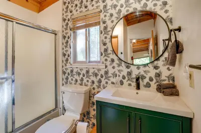 a bathroom with a toilet and a sink and a mirror at Charming Pinecrest Cabin with Private Deck in Strawberry