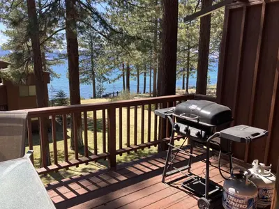 a grill on a deck with a view of the water at Tahoe Enchantment in Zephyr Cove