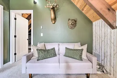 a living room with a white couch with pillows at 2 Mi to Tahoe Donner Ski Resort Forest-View Haven in Truckee