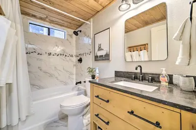 a bathroom with a sink and a tub and a toilet at 2 Mi to Tahoe Donner Ski Resort Forest-View Haven in Truckee