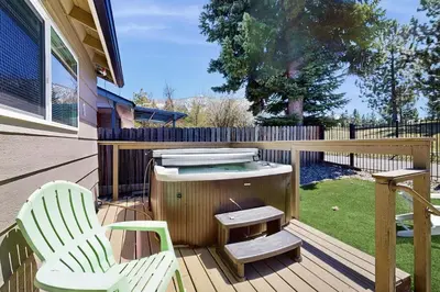 a deck with two chairs and a hot tub and a grill at Escape at Edgewood in Stateline